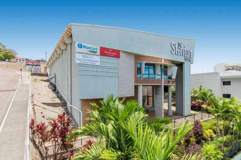 Aerial view of a healthcare real estate with few cars parked in front of it.